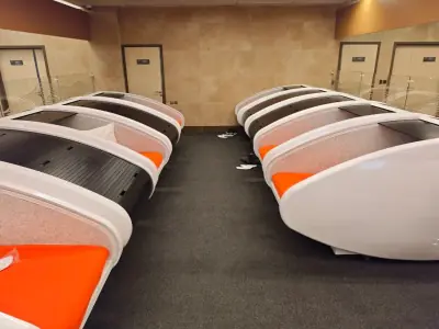 Salle de l’hôtel capsule de l’aéroport de Krasnoïarsk : deux rangées de capsules individuelles aux plaids orange