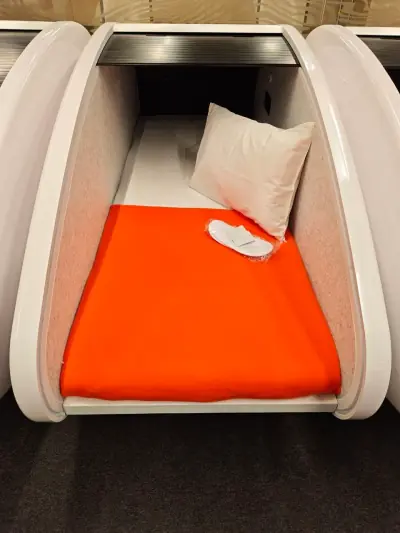 Capsule individuelle Solo à l’aéroport de Krasnoïarsk : matelas avec linge propre, oreiller, plaid orange et chaussons jetables