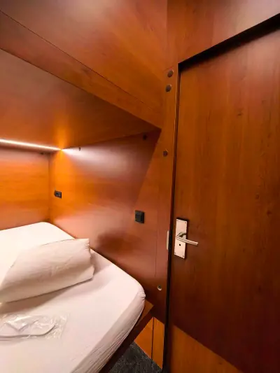 Вид сбоку на нижнюю капсулу Инь-Ян GettSleep: кровать и входная дверь с красной LED-подсветкой
